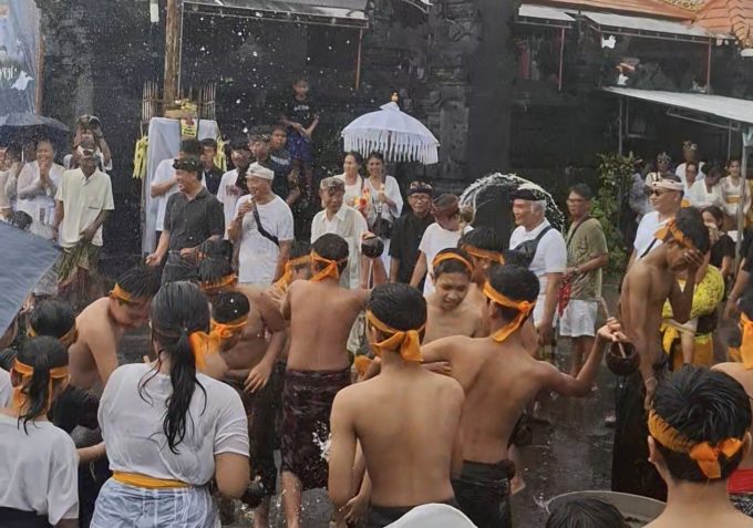 Hujan: Warga Banjar Teba, Jimbaran tampak antusias melaksanakan tradisi Siat Yeh di bawah guyuran hujan.